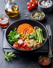 Healthy vegetarian salad. Pumpkin, quinoa, chickpea, tomatoes, green salad. Buddha bowl. Slate background.