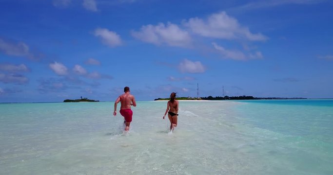 funny lovely couple teasing each other, splashing water while moving towards an Island