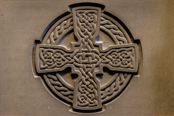 Wonderful embossed Celtic stone cross, full of details and textures in its elaborate carvings.