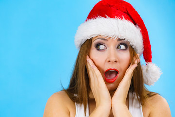 Surprised woman in santa claus hat