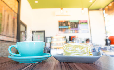 blue coffee cup and cake top on wooden coffee shop background.