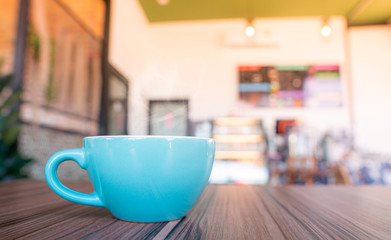 blue coffee cup top on wooden coffee shop background.