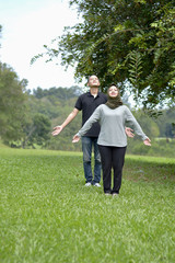 Young beautiful muslim couple standing together natural background.
