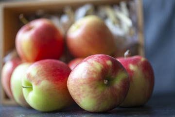 Close up of gala apples pouring out of wooden box