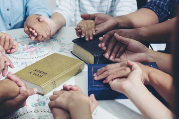 diverse hands holding hold hands circle to pray for God each other support together teamwork wiht bible on desk - 296004271