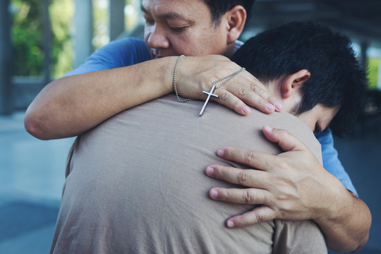 Male people christian adult health care hug to friend team support with cross crucifix in hand