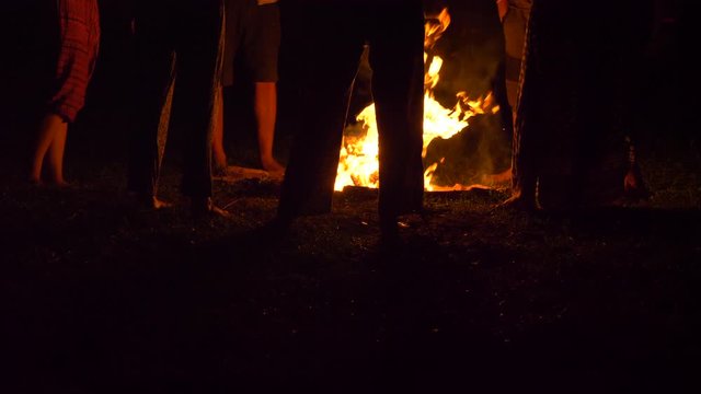 Friends Standing Around Fire At Camp, Slow Motion