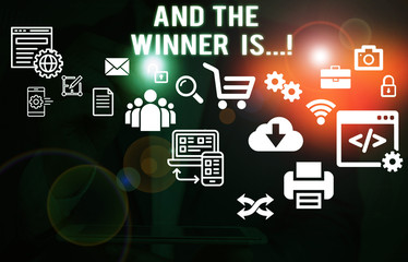 Text sign showing And The Winner Is. Business photo showcasing announcing who got first place at competition or exam Male human wear formal work suit presenting presentation using smart device