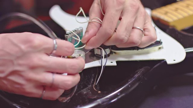 Guitar maker analyze wires inside an electric guitar