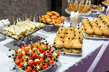 Buffet table of reception with burgers, cold snacks, meat and salads