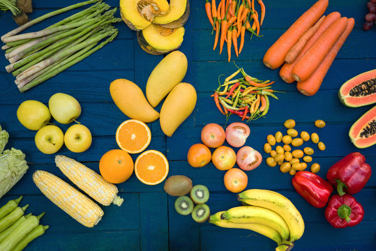Flat lay of fresh  fruits and vegetables for background, Different fruits and vegetables for eating healthy, Colorful fruits and vegetables on blue plank background
