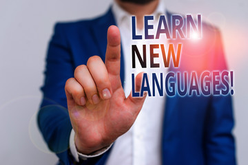 Word writing text Learn New Languages. Business photo showcasing developing ability to communicate in foreign lang Businessman in blue suite and white shirt pointing with finger in empty space