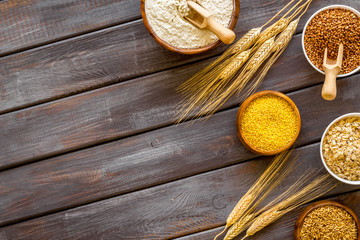 Healthy food. Cereals - rice, oats, buckwheat - in bowls on dark wooden background top view frame copy space