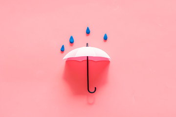 Rain concept. Umbrella and drops on pink background top view copy space