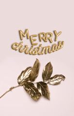 Merry Christmas text lettering in gold metallic foil balloon shapes with golden leaves on pink background, elegant and feminine, perfect for greeting cards, headlines, title, promotions.
