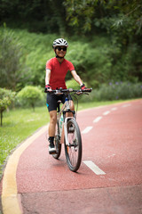 Obraz premium Woman cyclist riding mountain bike outdoors