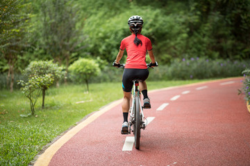 Woman cyclist riding mountain bike outdoors