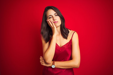 Young beautiful woman wearing sexy lingerie over red isolated background thinking looking tired and bored with depression problems with crossed arms.
