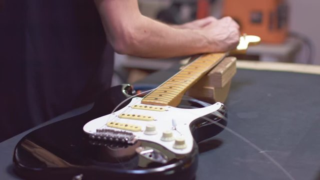 Guitar maker repairs strings of a guitar