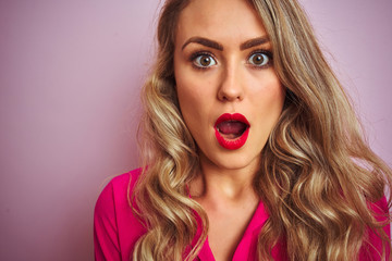 Young beautiful woman wearing elegant shirt standing over pink isolated background scared in shock with a surprise face, afraid and excited with fear expression