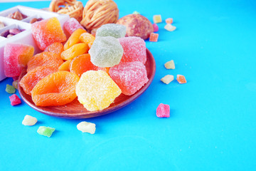 eastern sweets with date, marmalade, dried apricots, candied fruits assortment and metal vase on...