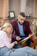 Psychoanalyst holding folder and speaking to client