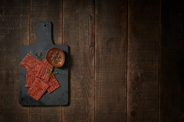 Luxurious image of jerky and pepper on vintage table.