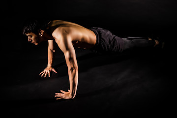 Fototapeta na wymiar sport man at fitness gym club doing push up exercise for body and showing muscle bodybuilding on black backgrounds, fitness concept, sport concept