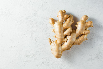Fresh ginger root on white textured background
