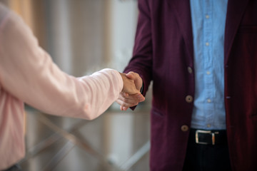 Psychoanalyst wearing dark jacket shaking hand of client