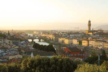 Fototapeta na wymiar Florence city during golden sunset. Panoramic view of the river Arno with Ponte Vecchio bridge and Palazzo Vecchio palace, Florence, Italy.