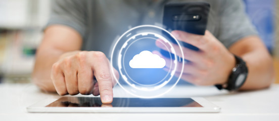 close up businessman hand touchscreen on digital tablet and smartphone to transfer or synch data upload and download from cloud computing service with virtual interface for technology business concept