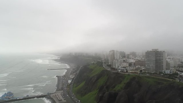 FORWARD Aerial drone view of Miraflores and cliff in a cloudy day of winter, Lima, Peru