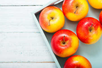 apples at blue tray, white wood table