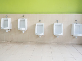 Empty row of outdoor urinals men public toilet.Close up white urinals in men's bathroom.White ceramic urinals for man in toilet room.Gentlemen restroom in the restaurant.Interior men's toilet.
