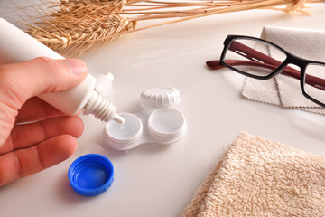Hand filling a contact lens case with a solution bottle