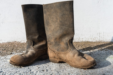 Dirty old leather work boots. Boots in the mud.