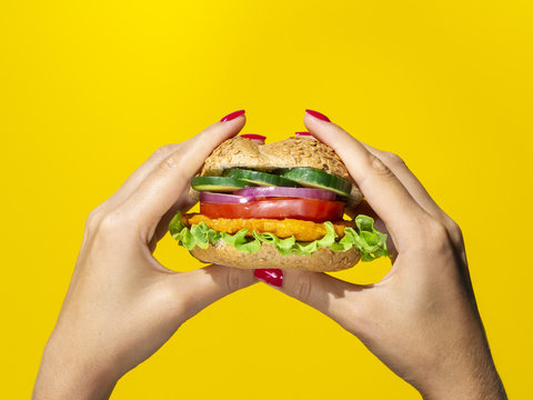 Close up view tasty burger on yellow background