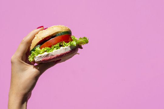Juicy burger on pink background with copy space