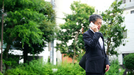 スマホで通話する中高年男性