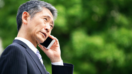 スマホで通話する中高年男性