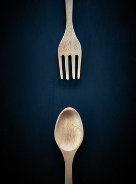 Wooden spoon and fork. On dark  table background