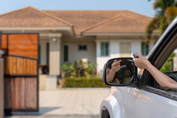 Woman in car, hand opening the automatic gate by using remote control. The auto door and security...