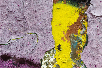 Surface texture with violet and yellow paint and many cracks on concrete wall. For abstract backgrounds.