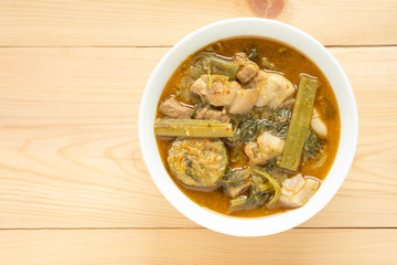 Pork curry with thai morning glory with Red Curry in white bowl on wooden background. Thai food.