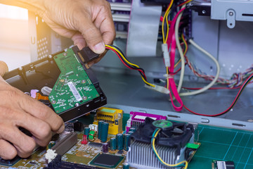 Closeup image of technician man hand changing the hard drive of pc competer . Maintenance  and repair computer hardware  service concept. - obrazy, fototapety, plakaty