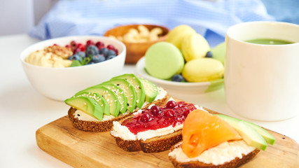 breakfast top view white background. oatmeal with berries, toasts on a wooden tray, nuts, coffee