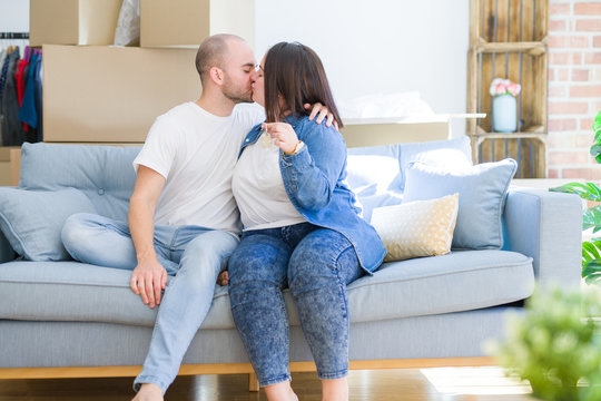 Young couple sitting on the sofa smiling very happy showing keys of new home, moving and buying new apartmet concept