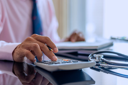 Male doctor or physician accounting medicine costs with stethoscope and computer notebook on the desk at modern office at clinic or hospital. Healthcare costs and fees ,Medical finance concept.