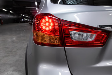 Close-up taillight of a new halogen silver crossover car. Exterior of a modern car.